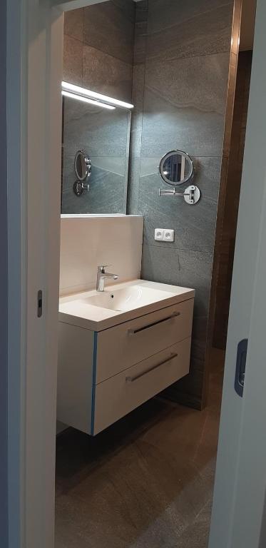 łazienka z umywalką i lustrem w obiekcie Flat Jindrichuv Hradec w mieście Jindrichuv Hradec