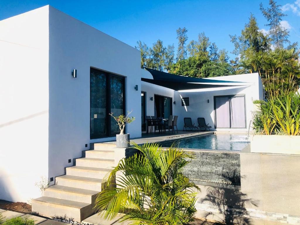 a white house with a swimming pool and stairs at Villa de Luxe Mon Voyage 500m de la plage in Albion