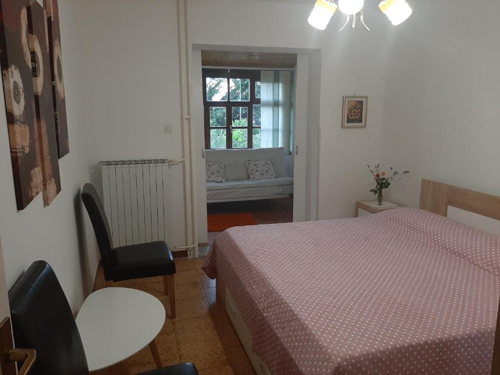 een slaapkamer met een bed, een stoel en een raam bij Clara 2 in Poreč