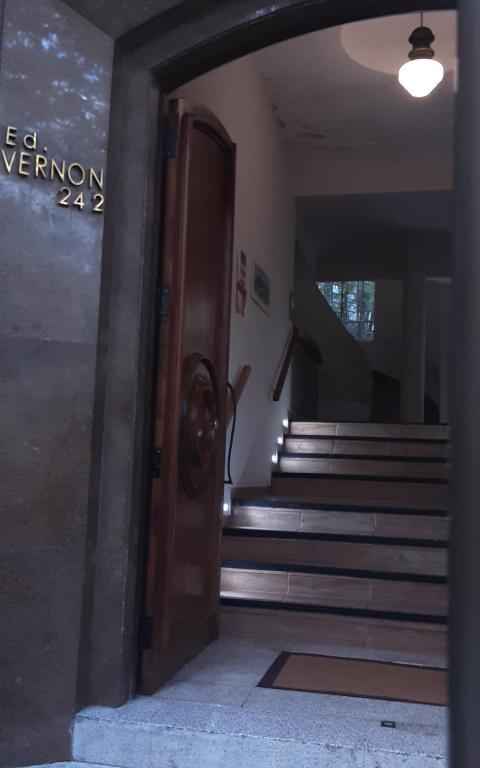 a dog is standing at the door of a building at Loft aconchegante no Leblon in Rio de Janeiro