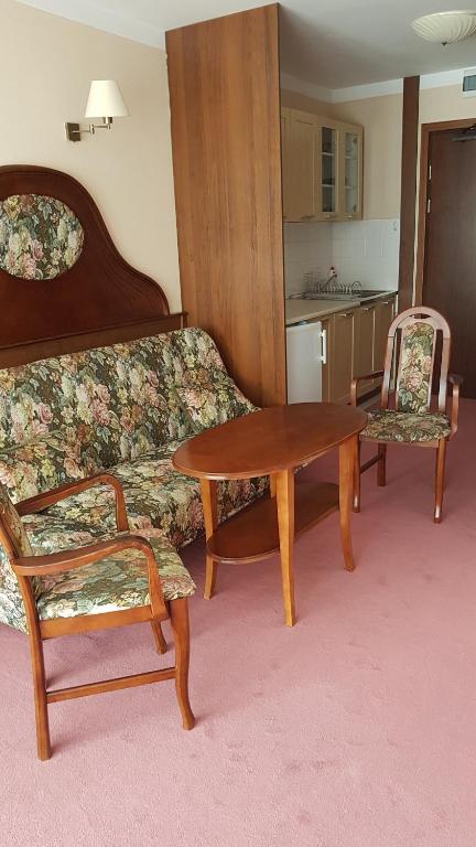 a living room with a couch and a table and chairs at Apartamenty rodzinne przy plaży in Kołobrzeg