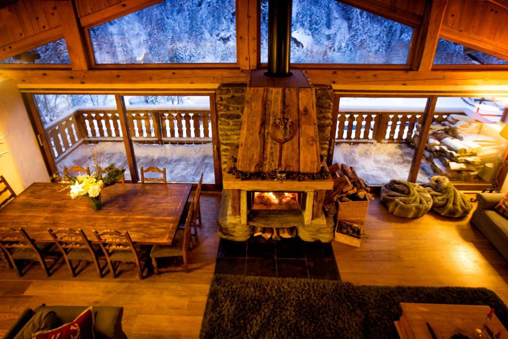a living room with a wooden table and a fireplace at Chalet Marron by Tarentaise Properties in Sainte-Foy-Tarentaise