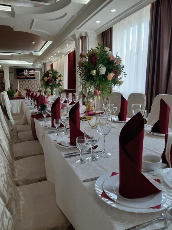 a long table with wine glasses and red napkins at Ідилія in Zhensna Polʼska