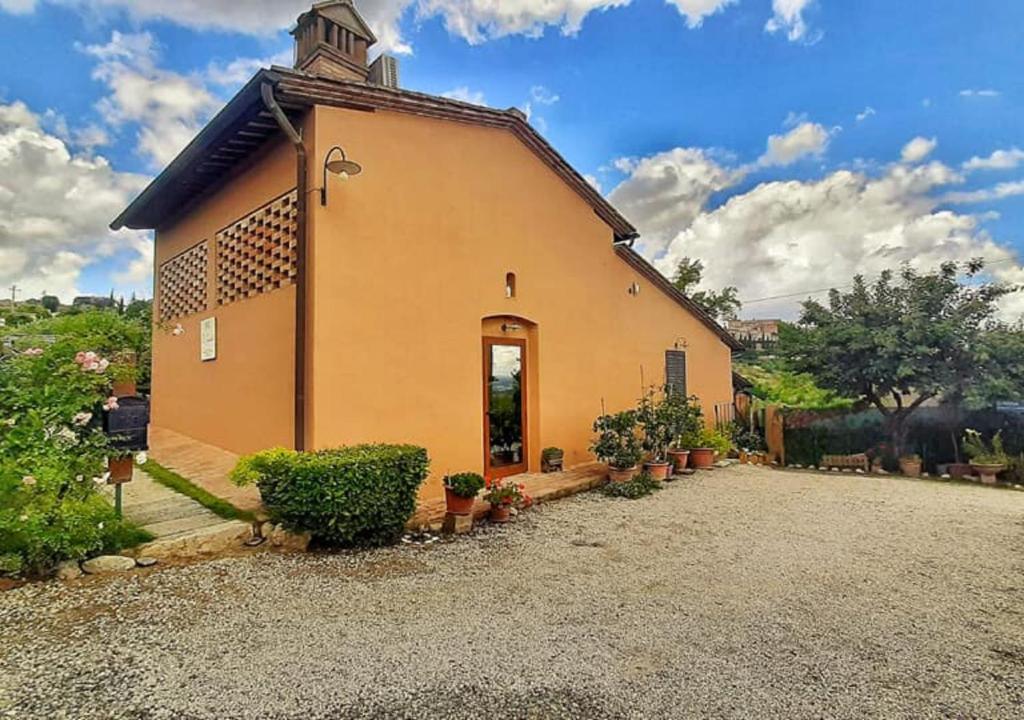 Una pequeña iglesia con plantas delante. en B&B Il Fienile San Gimignano, en San Gimignano