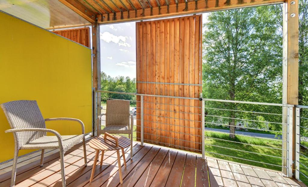 einen Balkon mit 2 Stühlen und einem großen Fenster in der Unterkunft Apartmány Tadeáš in Stožec
