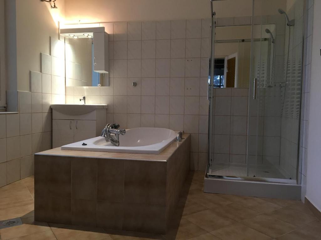 a bathroom with a sink and a shower at Régimódi Apartman in Siófok