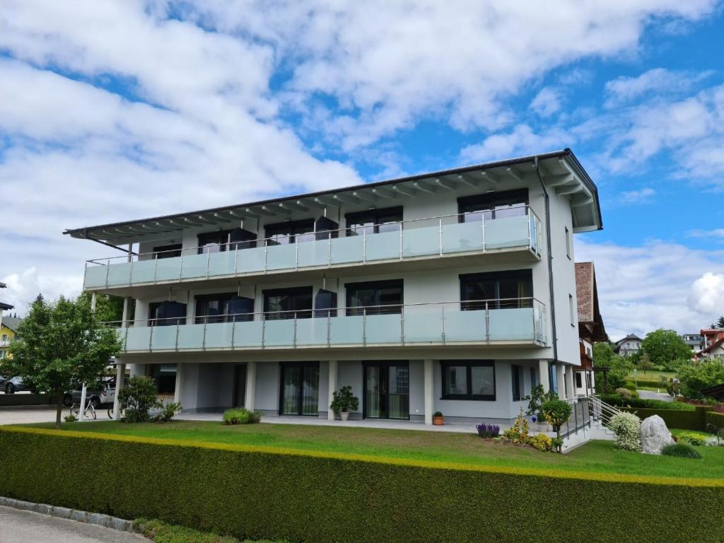 un edificio blanco con muchas ventanas en Ferienwohnungen Petschnig 1 en Drobollach am Faakersee