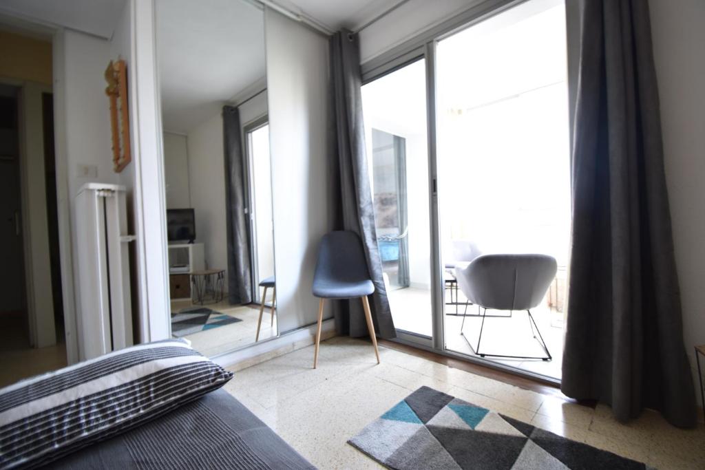 Schlafzimmer mit einem Bett und einem großen Glasfenster in der Unterkunft T2 rénové en centre ville Port Royal in Le Grau-du-Roi