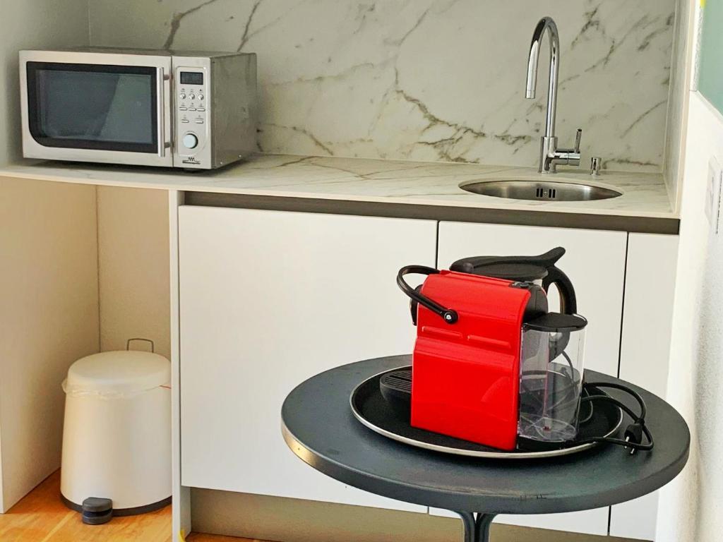 a kitchen with a coffee maker on a table next to a microwave at Guesthouse Lochergut in Zürich
