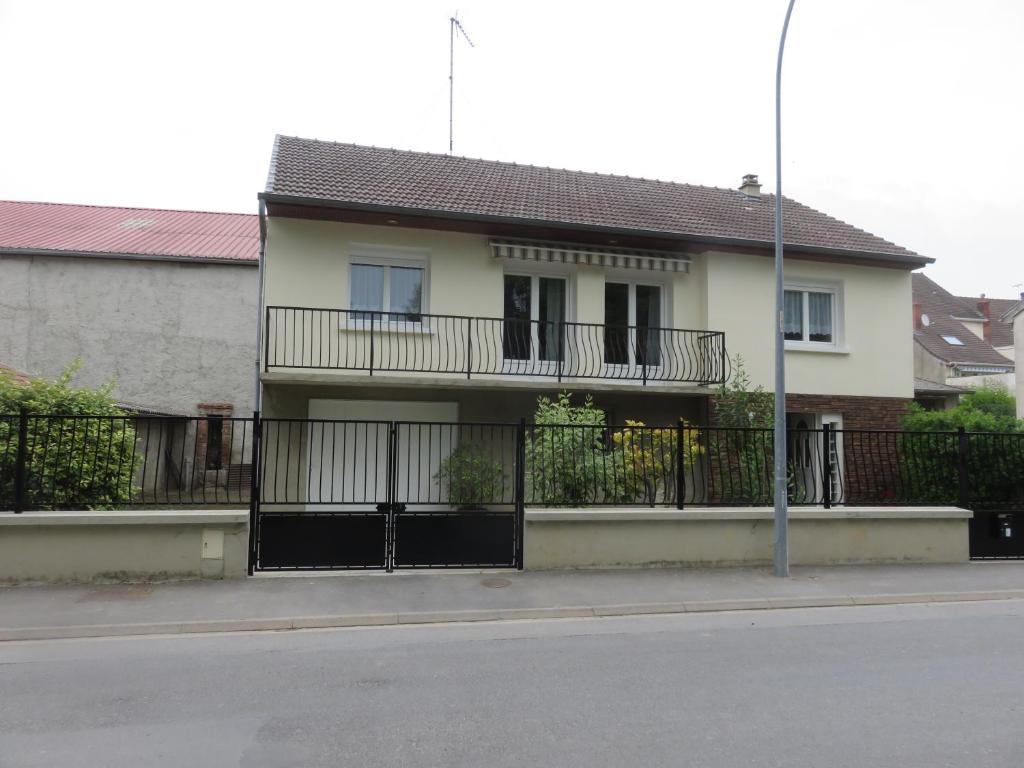 een wit huis met een balkon en een hek bij Le gîte du Coche avec vue sur la Marne in Damery