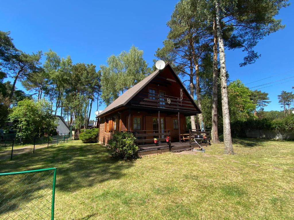 a log cabin with a clock on top of it at Alga in Mrzeżyno