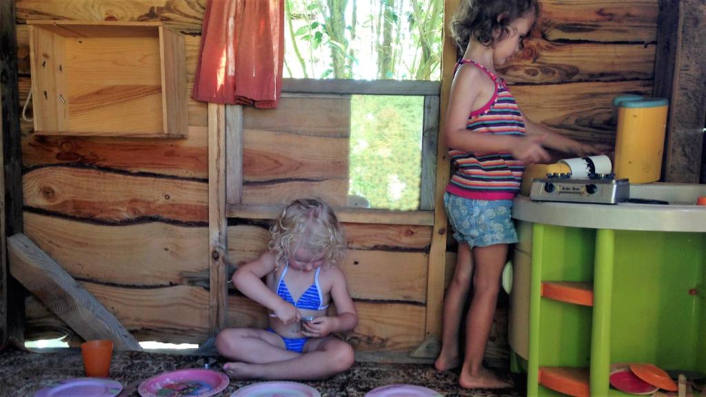 two young girls in a play house with a woman at Maison d hôtes Casa Sana in Pillac