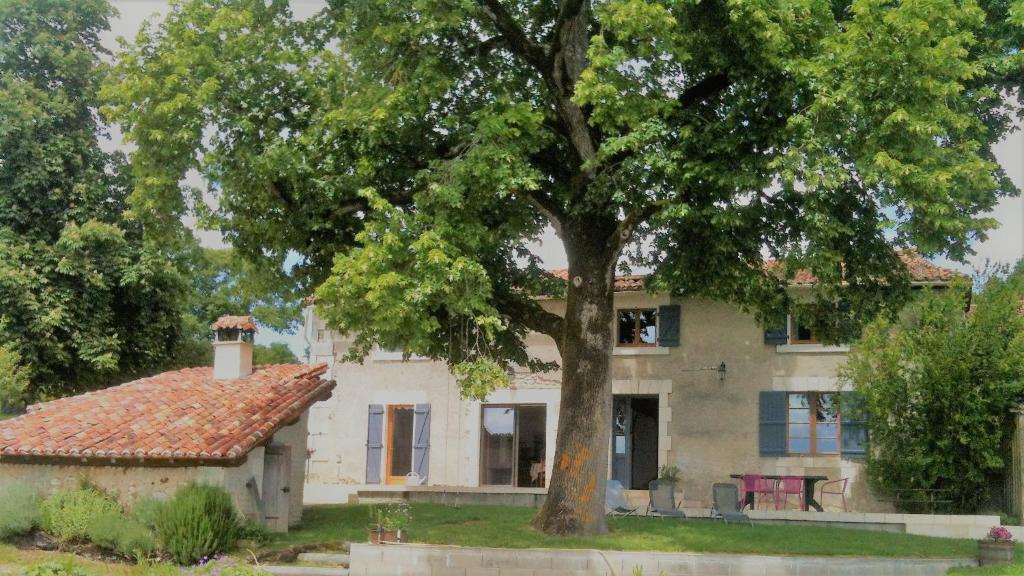 an old house with a tree in front of it at Maison d hôtes Casa Sana in Pillac