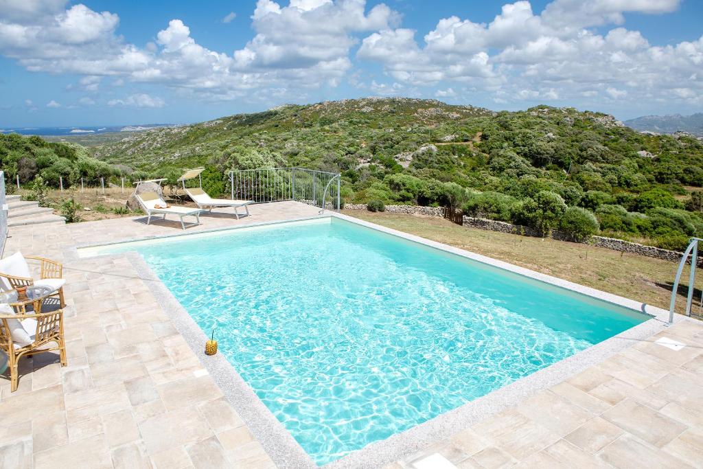 uma piscina com vista para uma montanha em La casa di Memmi Suites & Rooms em Santa Teresa Gallura