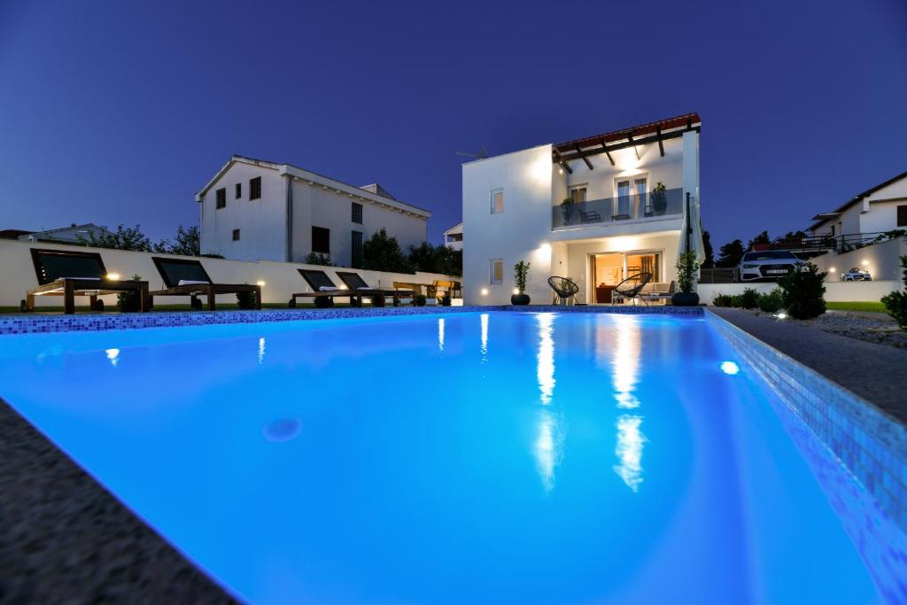 una piscina di fronte a una casa di notte di Villa Valentina a Privlaka (Brevilacqua)
