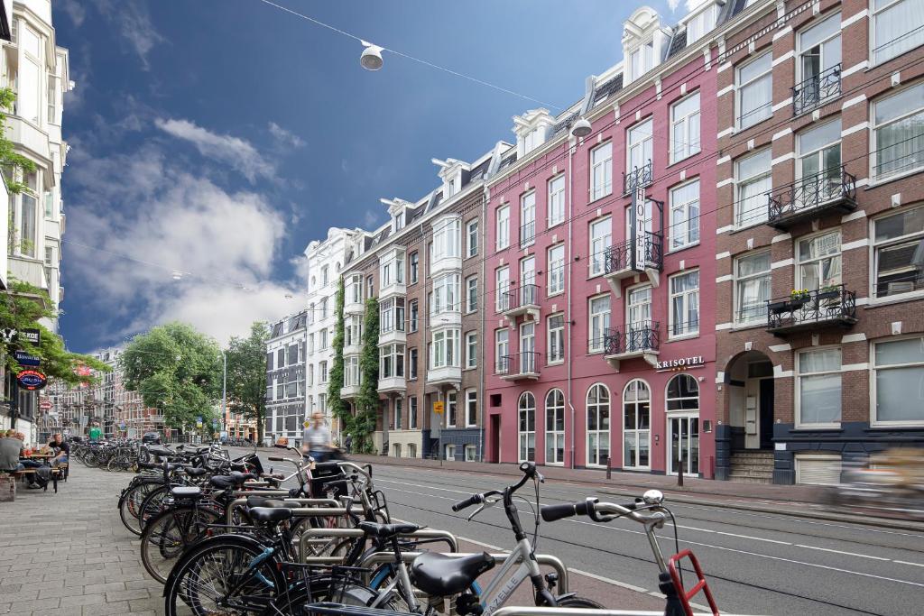 een rij fietsen geparkeerd in een stadsstraat bij Krisotel in Amsterdam