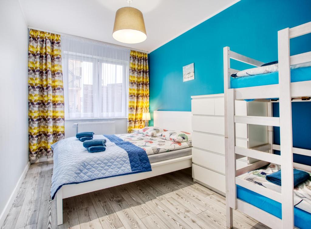 a bedroom with blue walls and bunk beds at Apartamenty Olivia in Władysławowo