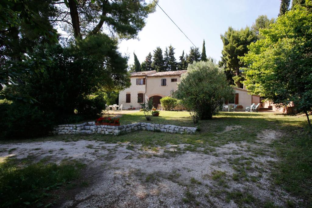 um grande quintal com uma casa ao fundo em Il Casale Delle Farfalle em Sirolo