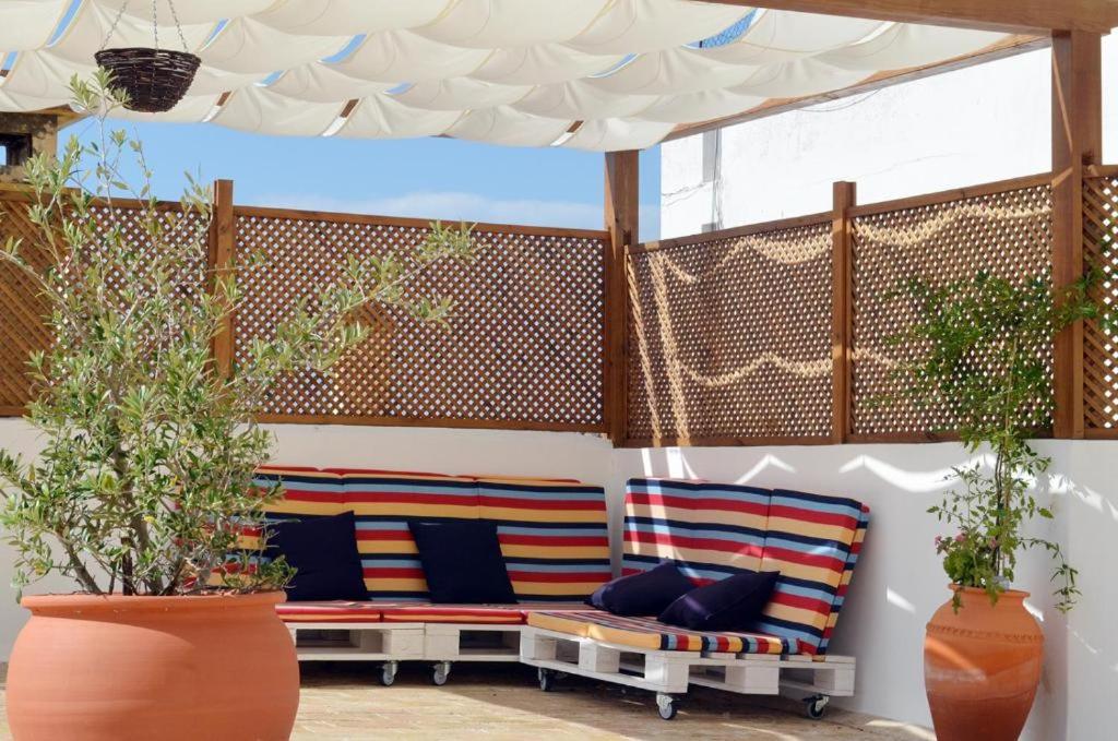 un patio con 2 bancos bajo un dosel en Casa aOrta, en Faro