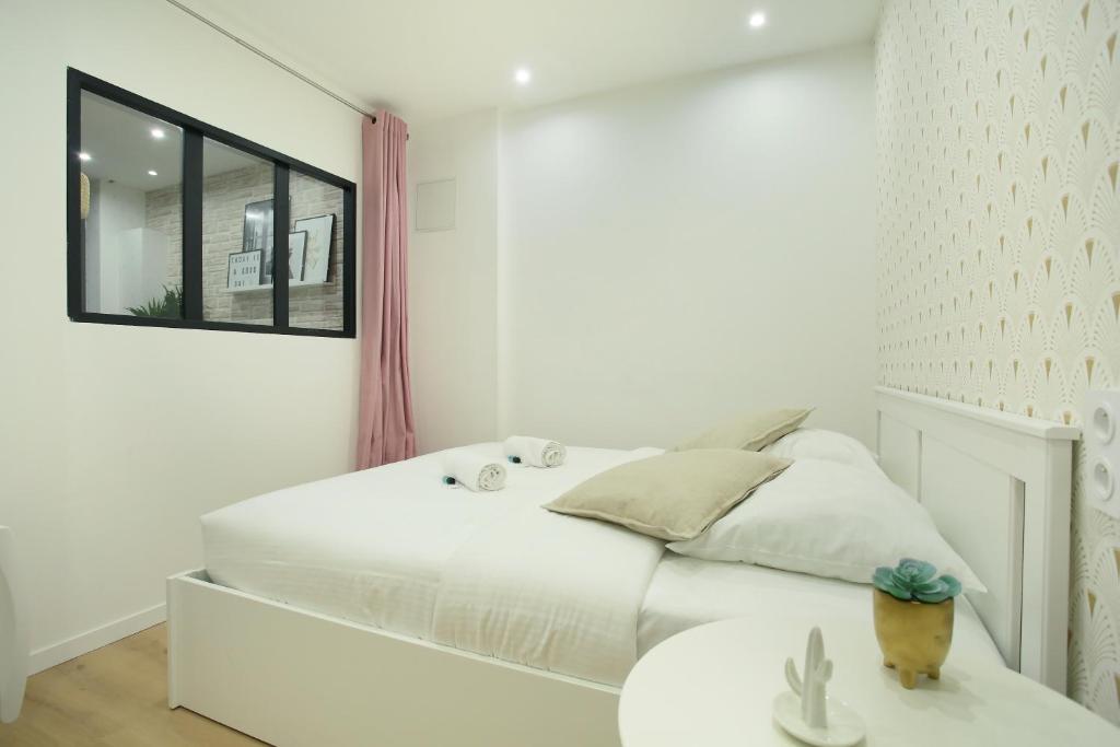 ein weißes Schlafzimmer mit einem Bett und einem Tisch in der Unterkunft Rent a Room - 253, 2BDR Center of PARIS in Paris