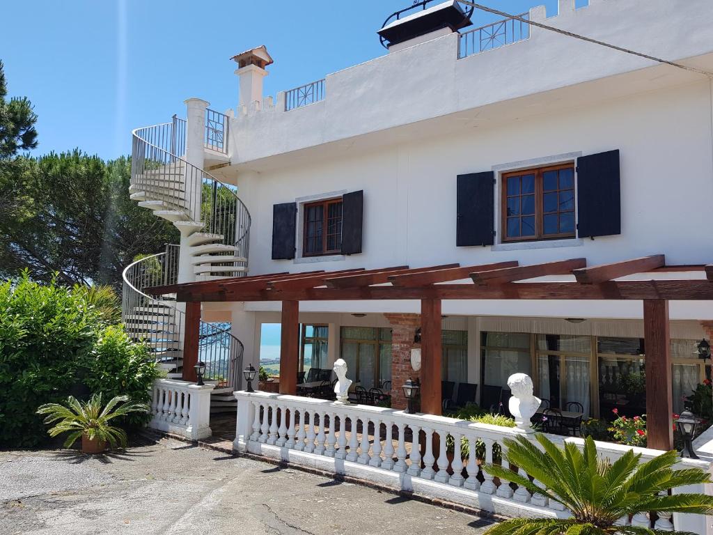 a large white house with a staircase in front of it at Hotel Ristorante Radar in Carrara