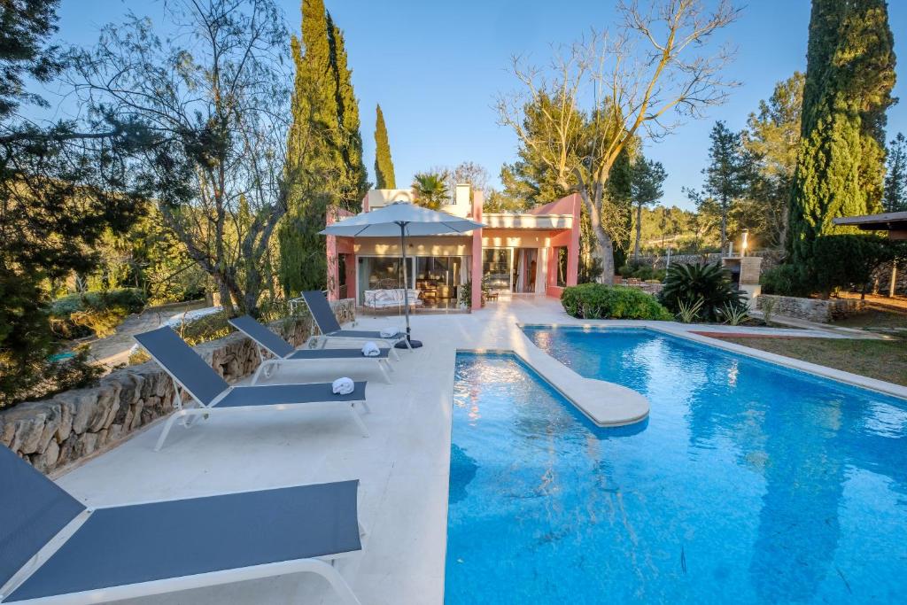 - une piscine avec des chaises longues à côté d'une maison dans l'établissement Can Jaume Curt, à Sant Rafael de Sa Creu