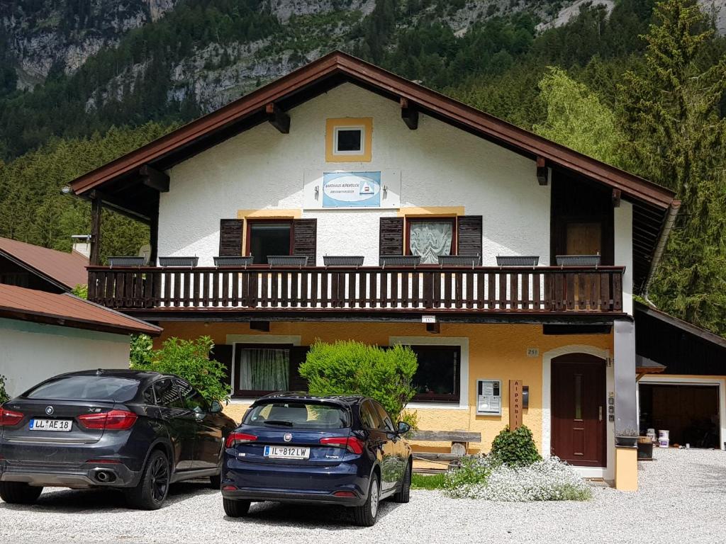 dois carros estacionados em frente a uma casa com varanda em Landhaus Alpenblick em Leutasch