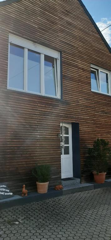 a wooden house with a white door and some plants at Gästezimmer Elly Dostert in Trittenheim