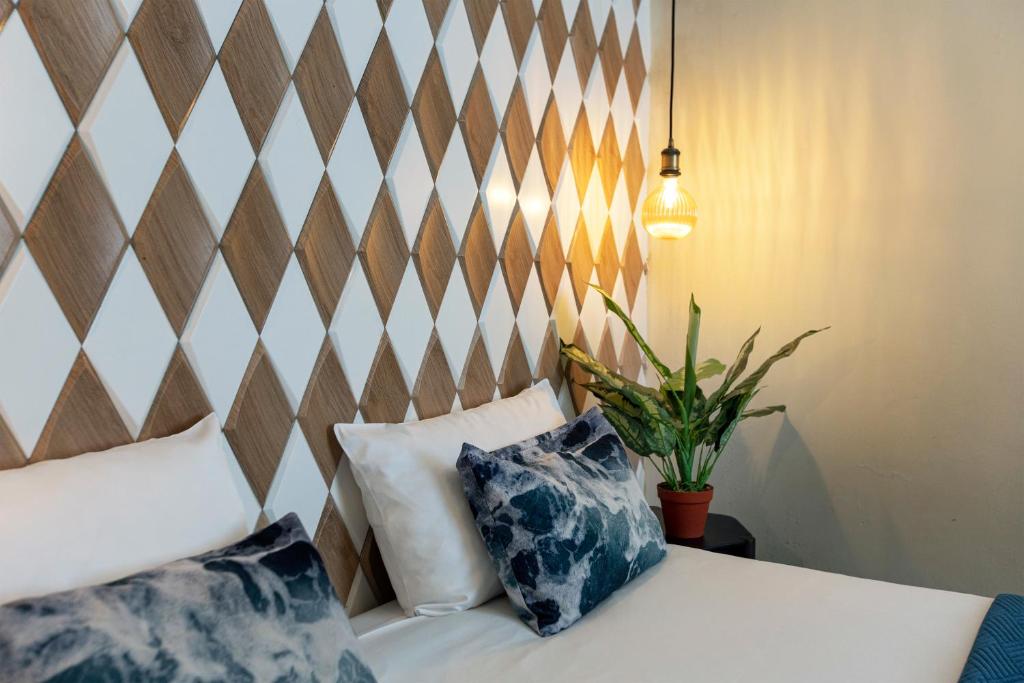 Zimmer mit einem Bett mit zwei Kissen darauf in der Unterkunft Quentin Golden Bear Hotel in Amsterdam