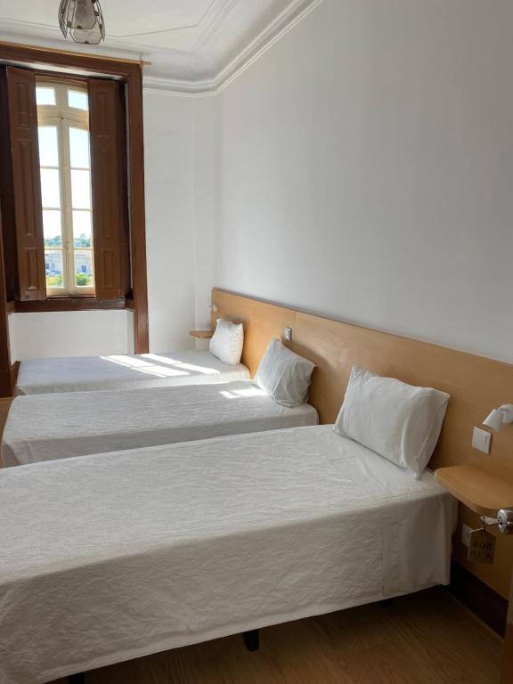 a row of beds in a hotel room at Guesthouse Lusa Atenas in Coimbra