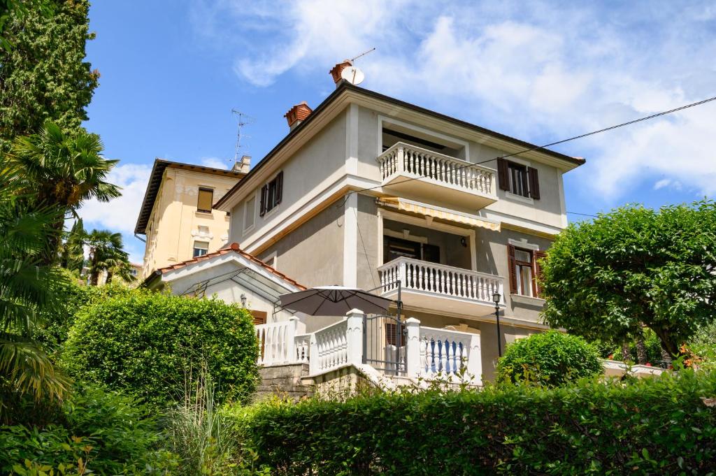 a large white building with balconies on top of it at Apartments Villa Salona in Opatija