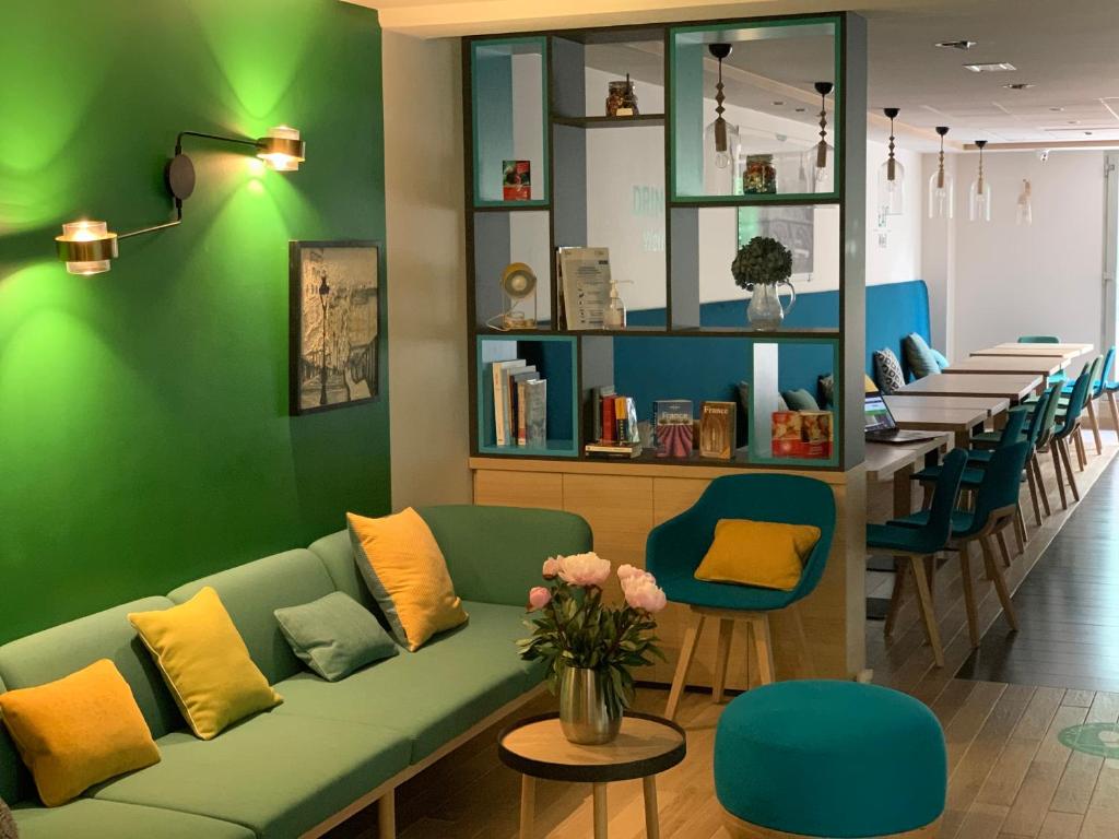 a waiting room with a green couch and a table at Holiday Inn Paris Montmartre, an IHG Hotel in Paris