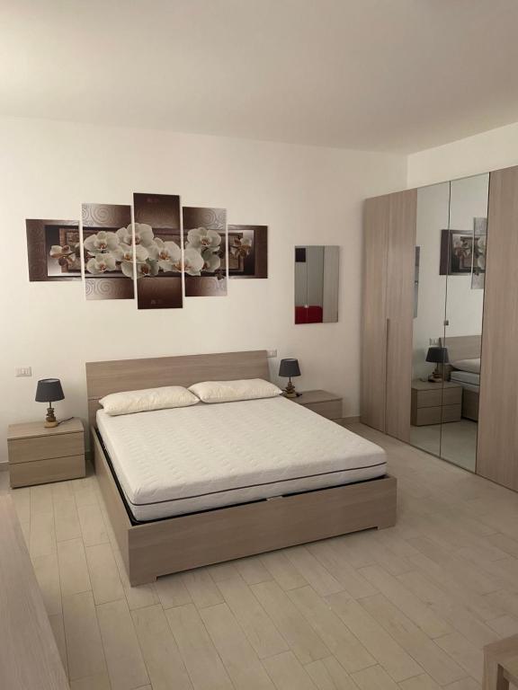 1 dormitorio con 1 cama y algunas fotos en la pared en senza pensieri via 4 novembre/via diaz, en Crema
