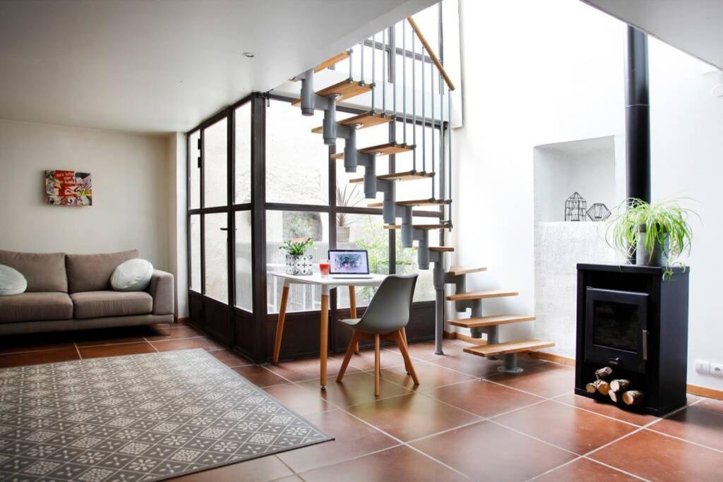 a living room with a spiral staircase and a table at Maison de Charme Rénovée in Cucuron