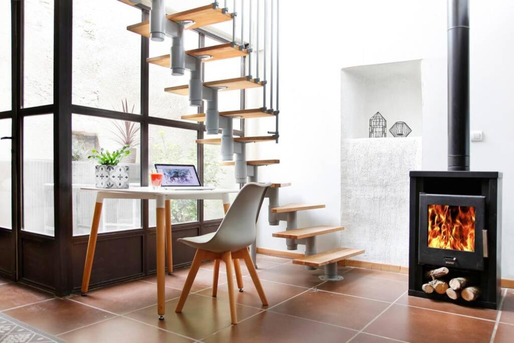 a living room with a table and a fireplace at Maison de Charme Rénovée in Cucuron