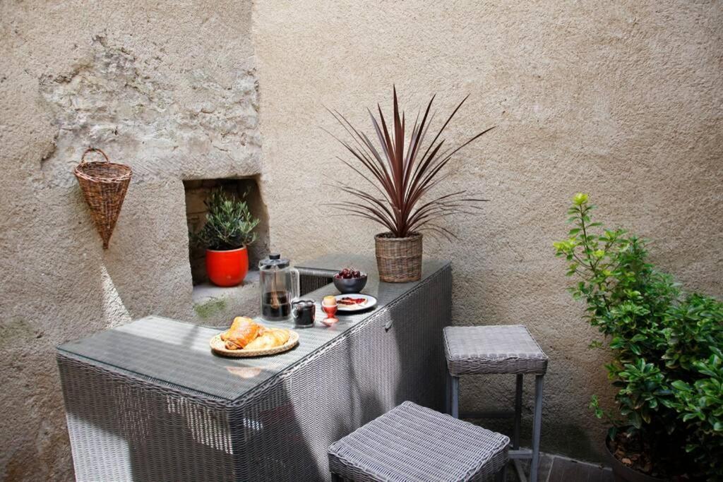 a table with a plate of food on a balcony at Maison de Charme Rénovée in Cucuron