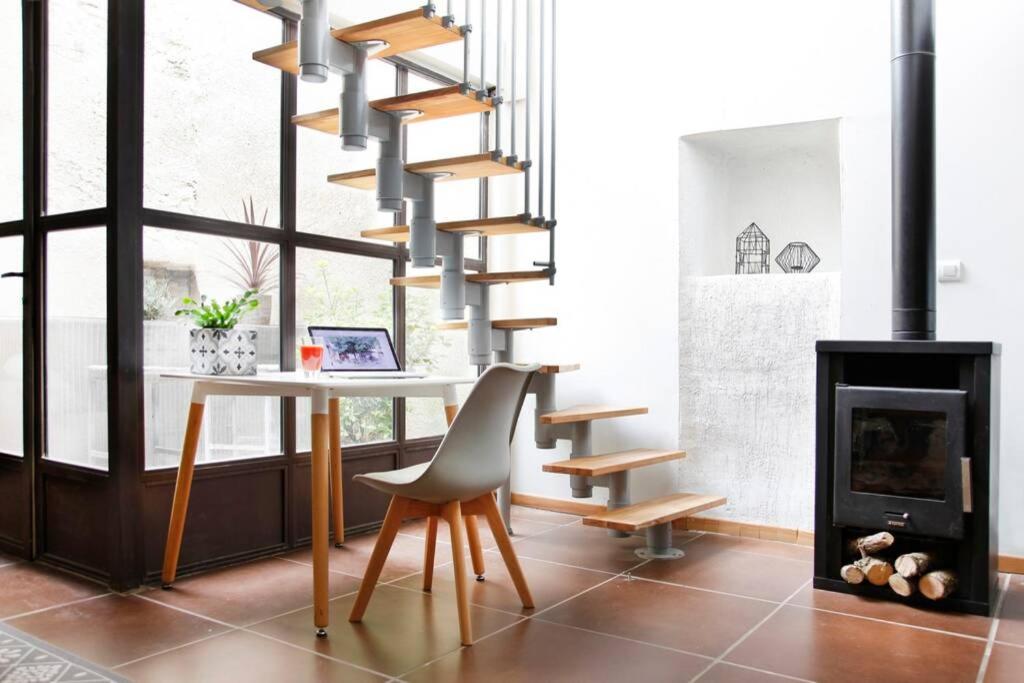 a staircase in a living room with a table and a chair at Maison de Charme Rénovée in Cucuron