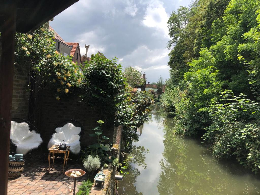 a view of a river next to a house at BRU-LAGOON Guesthouse in Bruges