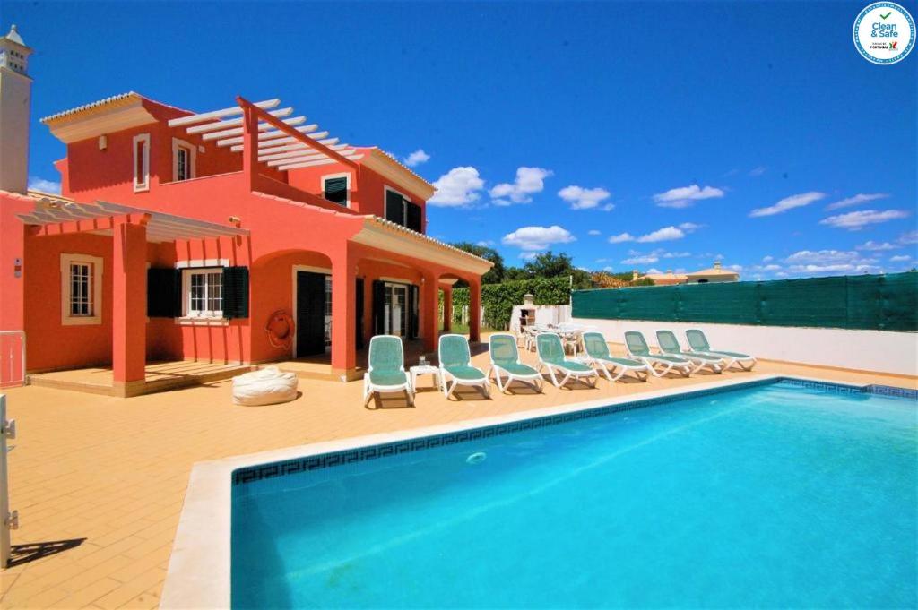 a villa with a swimming pool in front of a house at Villa Mikael - Free Wi-Fi - Aircon - Private Pool by bedzy in Albufeira