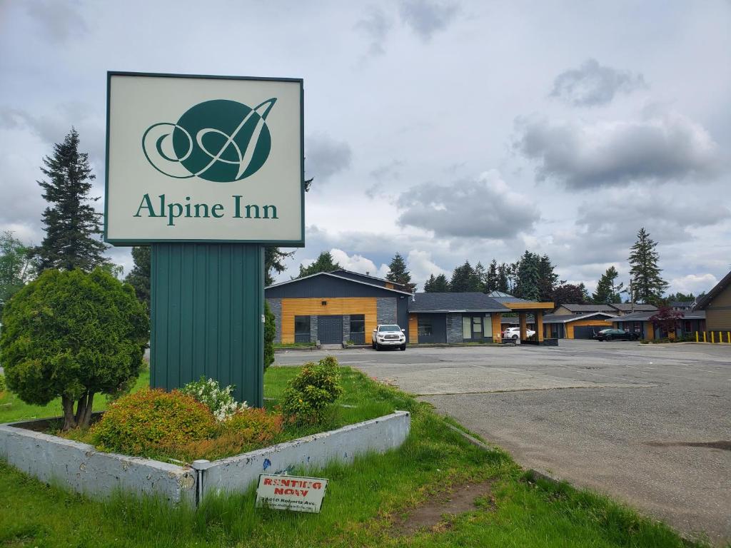 a sign for an airplane inn in a parking lot at Alpine Inn Abbotsford in Abbotsford