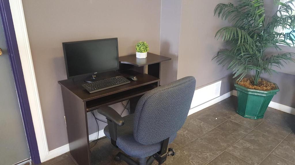 an office with a desk with a computer and a chair at Alpine Inn Abbotsford in Abbotsford