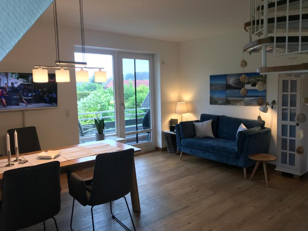 uma sala de estar com uma mesa e um sofá azul em Moin ! em Timmendorfer Strand