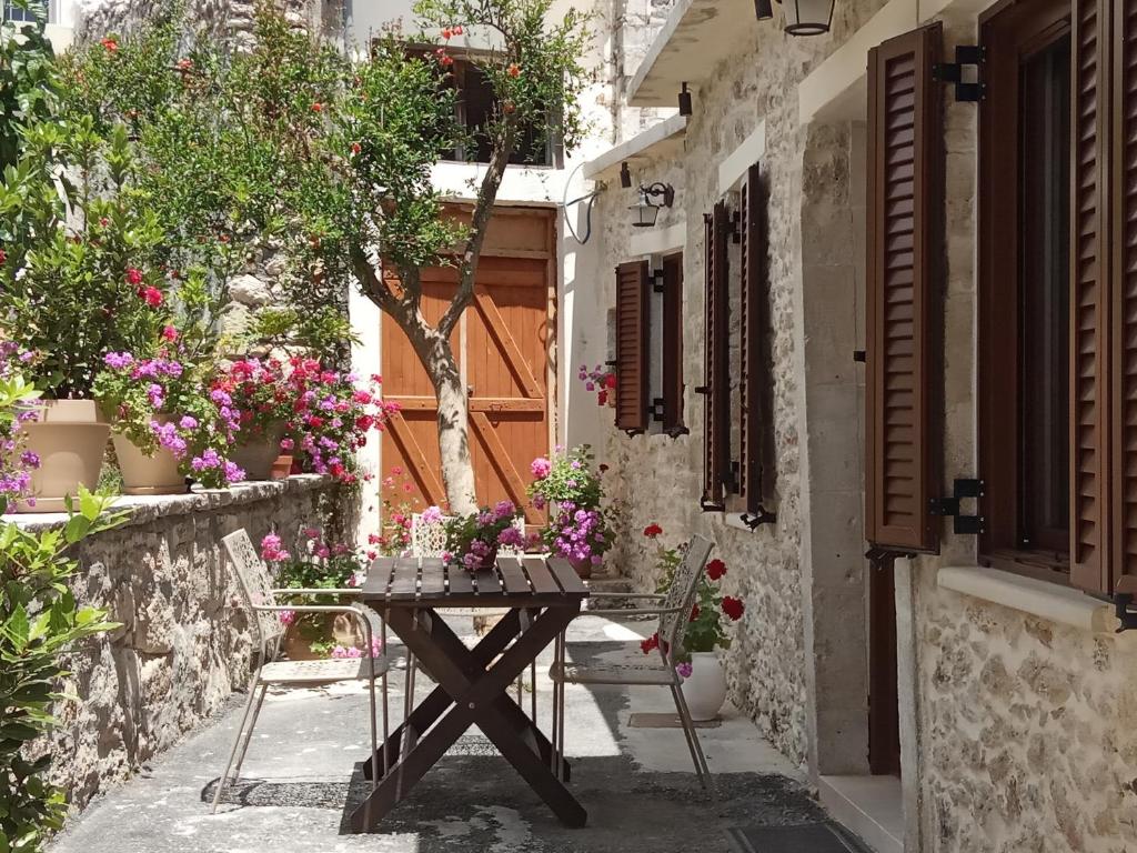a table and chairs in a courtyard with flowers at Archontiko Anastasia in Choudetsi