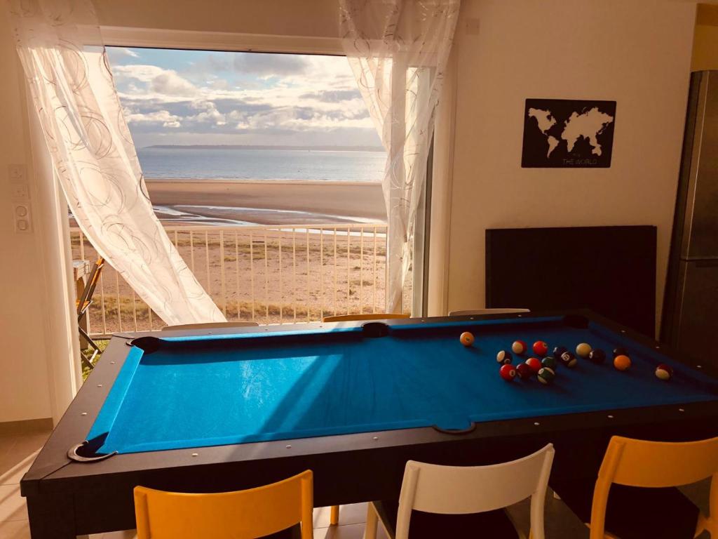 a pool table in a room with a view of the beach at Appartement "Envies D'ailleurs" Vue Mer in Saint-Brevin-les-Pins