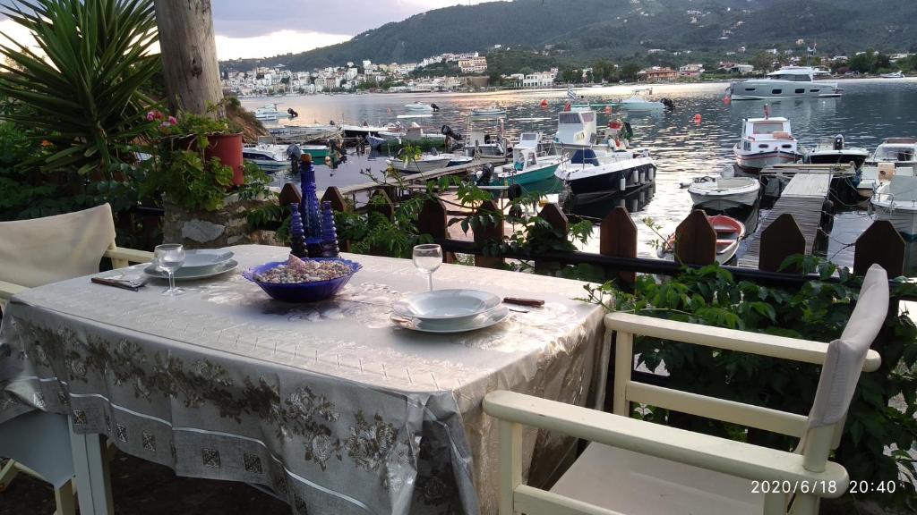 een tafel met borden en glazen erop met een jachthaven bij Skiathos Riviera Studios in Punta