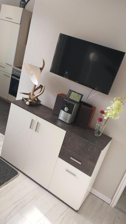 a living room with a tv and a white cabinet at Kuschelnest in Altenau