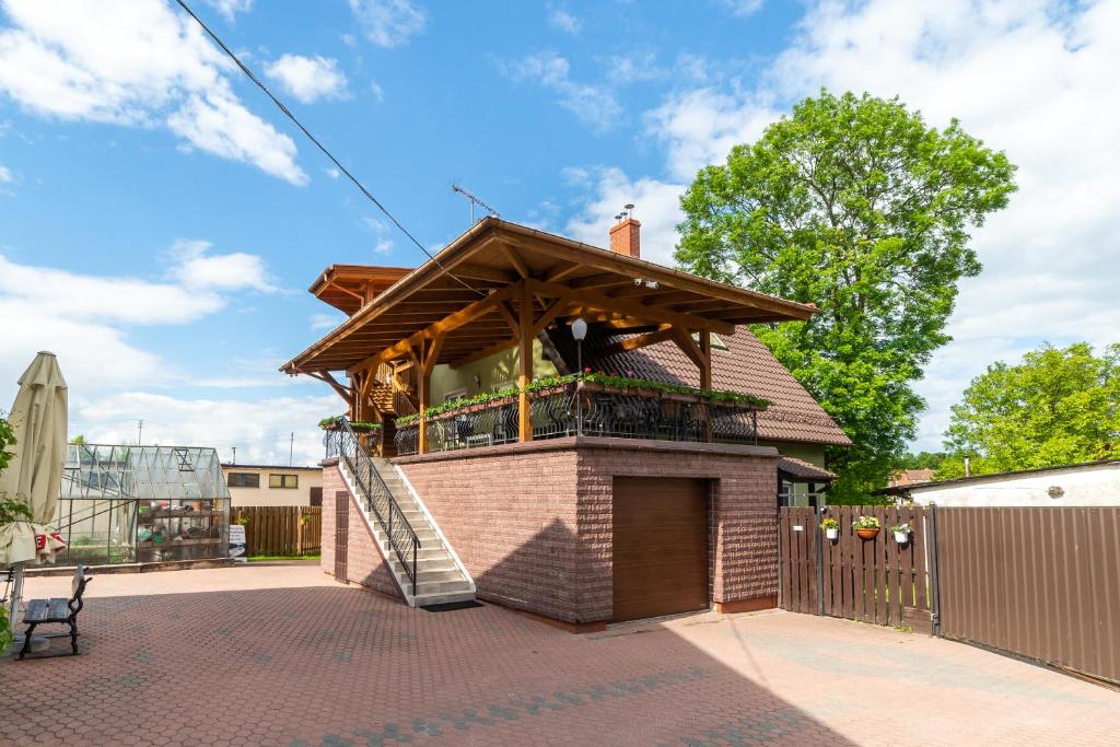 a building with a wooden roof on a patio at Willa ATA Mikolajki in Mikołajki