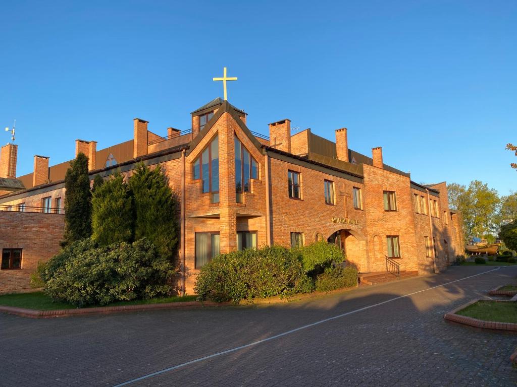 a large brick building with a cross on top of it at Ośrodek Gwiazda Morza in Grzybowo