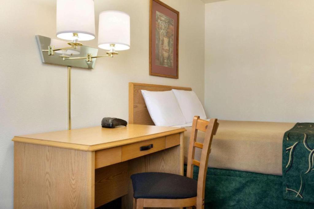 a room with a desk and a bed with a computer at Travelodge by Wyndham Yampa in Yampa