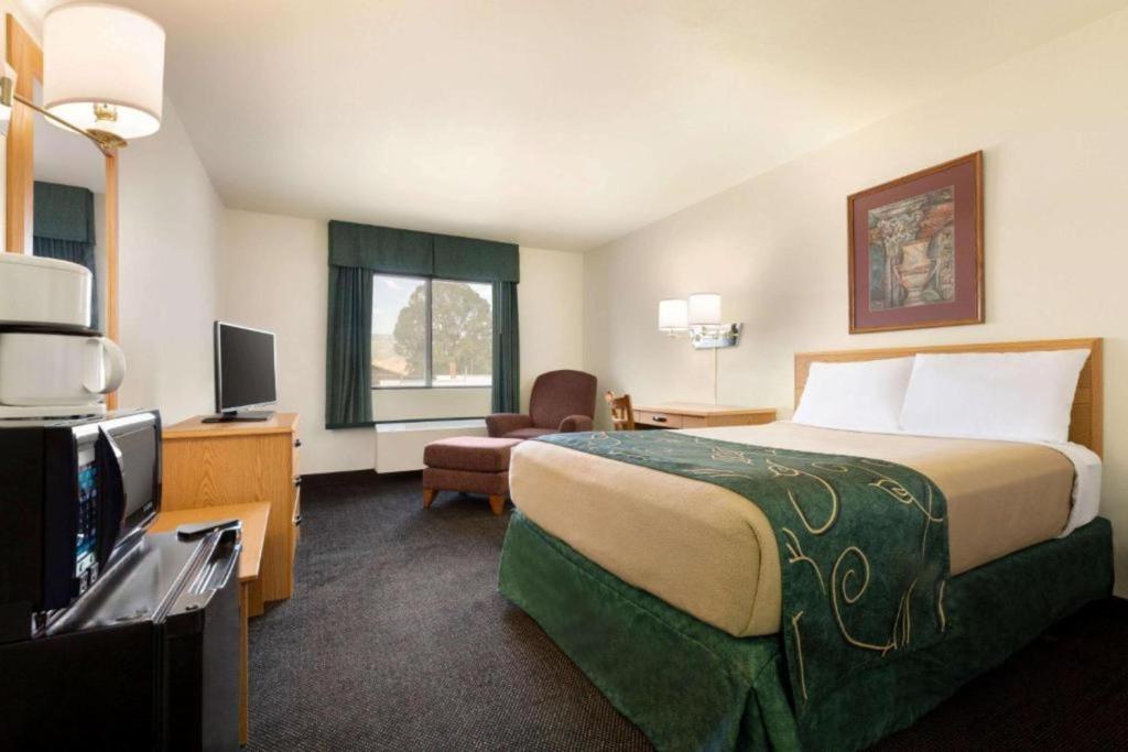 a hotel room with a large bed and a television at Travelodge by Wyndham Yampa in Yampa